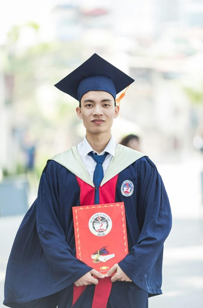 Proud graduate in academic gown holding diploma, celebrating academic success.